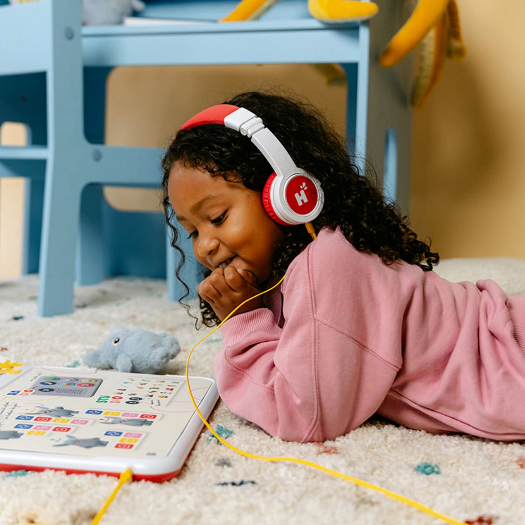 Une enfant allongée écoute HopiPlay avec le casque Hopi