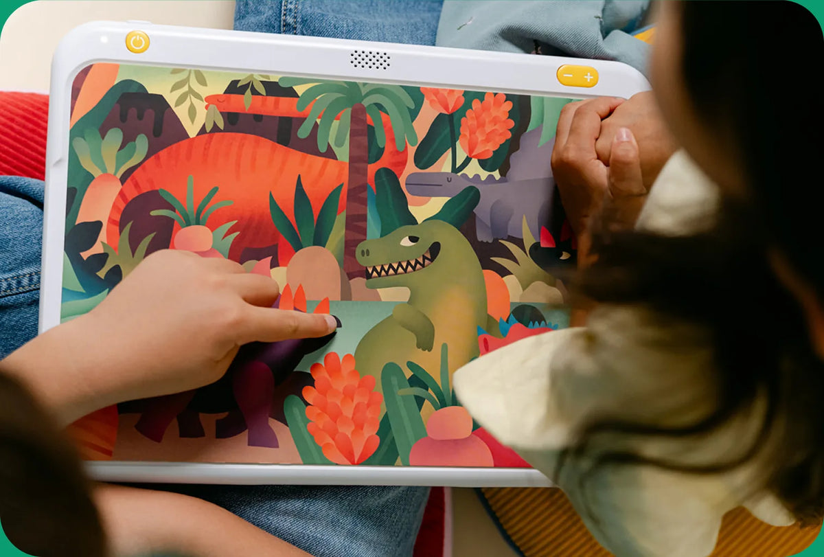 Un enfant touche l'illustration d'un dinosaure sur le lecteur HopiPlay