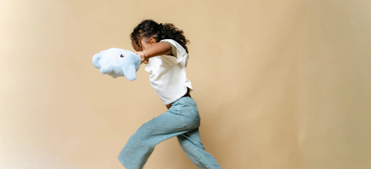 Une enfant court avec une peluche Hopi