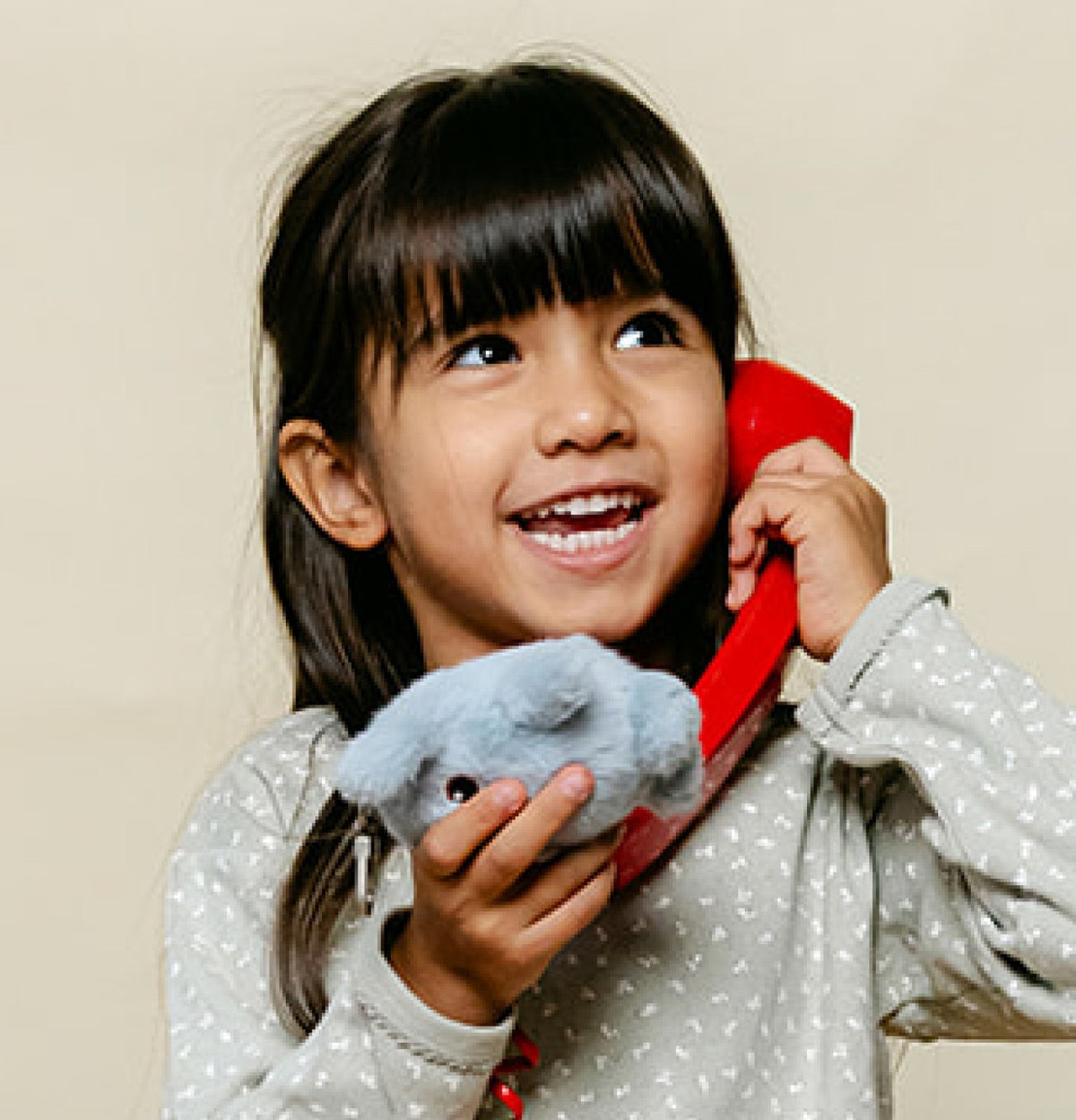 Une petite fille au téléphone avec sa peluche Hopi