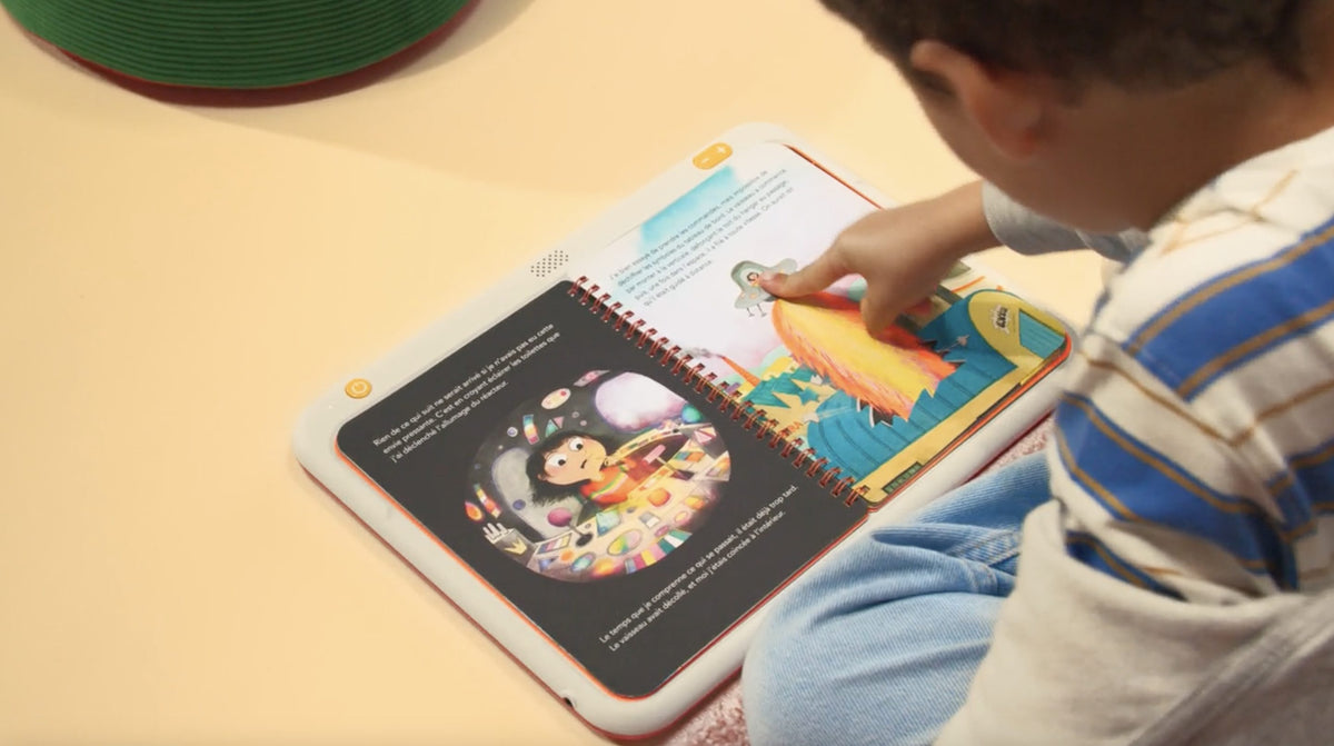 Enfant qui touche une page de livre posé sur la tablette HopiPlay