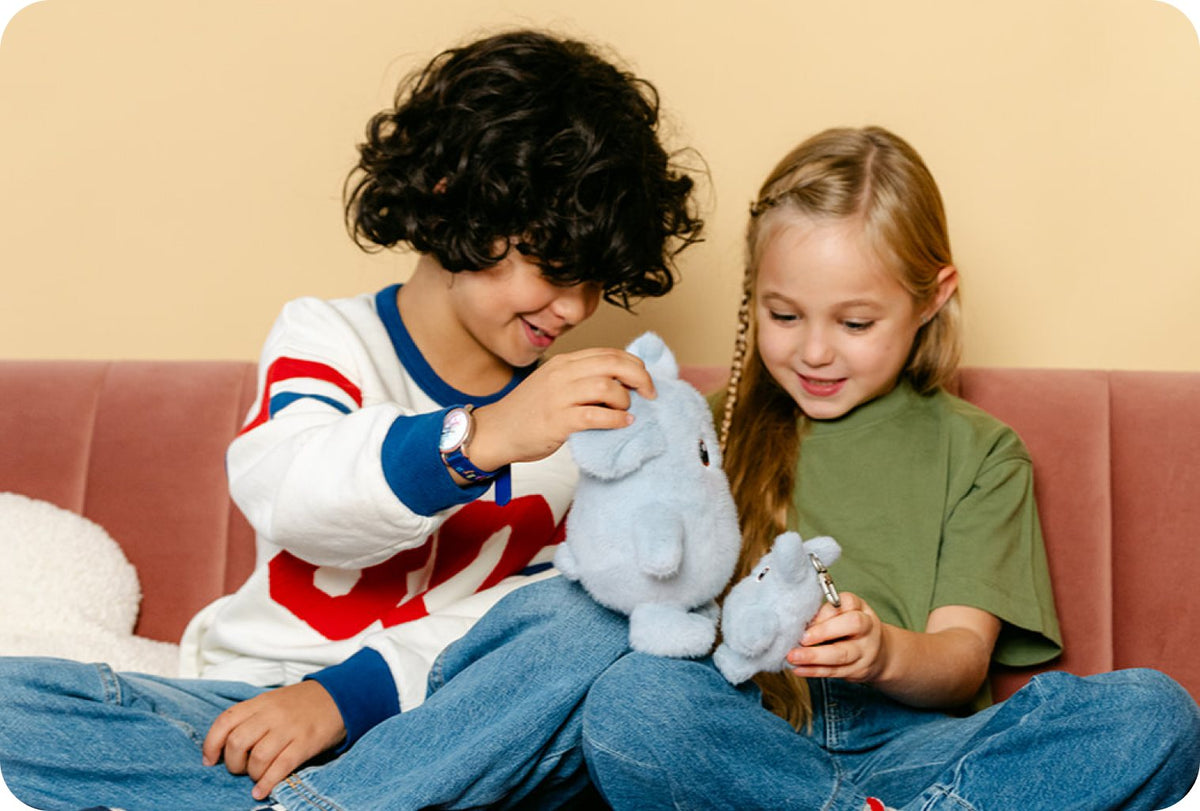 Deux enfants assis sur un canapé avec des peluches Hopi