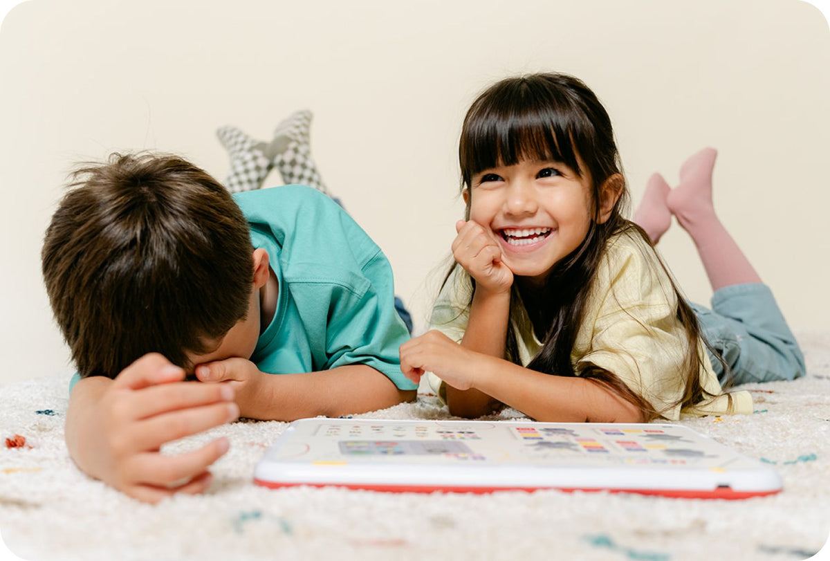 Un garçon et une fille allongés sur un tapis jouent avec HopiPlay