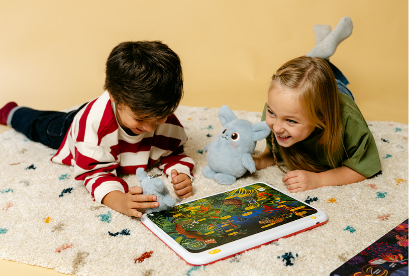 Deux enfants jouent ensemble avec HopiPlay sur un tapis